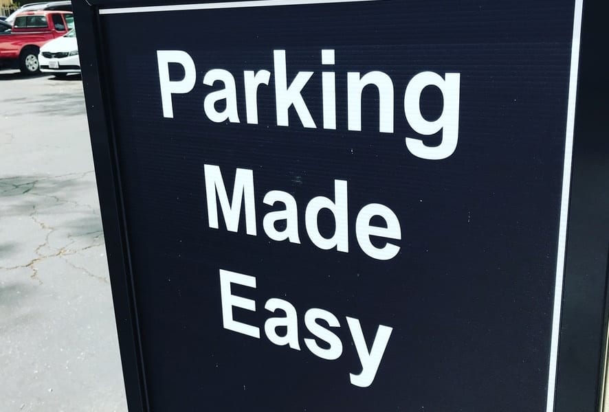 Uniformed parking lot attendant managing vehicle access at a commercial property